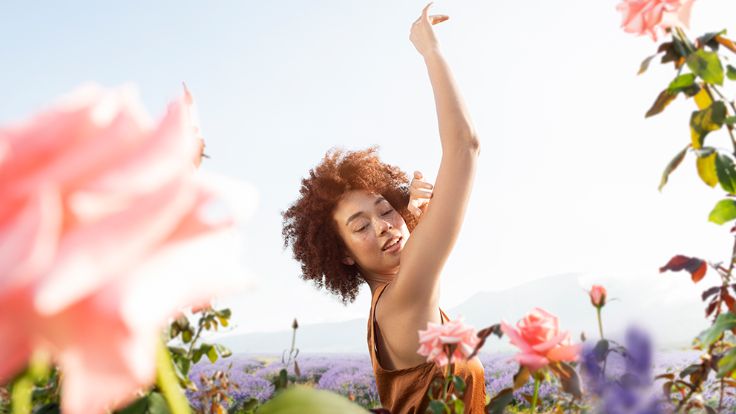 woman standing in meadow with flowers