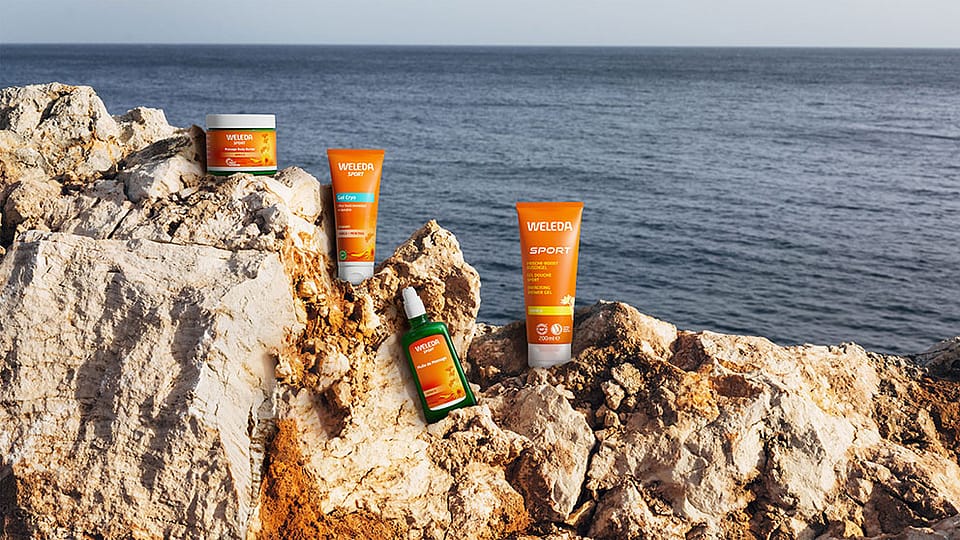 Weleda Arnica products on a rock by the sea